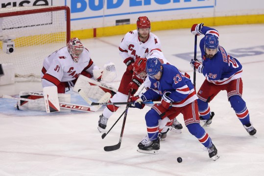 May 7, 2024; New York, New York, USA; New York Rangers defenseman Adam Fox (23) and left wing Chris Kreider (20) fight for the puck against Carolina Hurricanes left wing Jordan Martinook (48) and defenseman Jaccob Slavin (74) and goaltender Frederik Andersen (31) during the first overtime of game two of the second round of the 2024 Stanley Cup Playoffs at Madison Square Garden. Mandatory Credit: Brad Penner-USA TODAY Sports