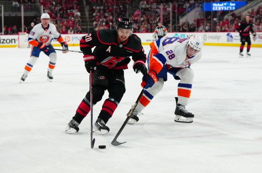 Apr 30, 2024; Raleigh, North Carolina, USA; Carolina Hurricanes center Sebastian Aho (20) skates with the puck past New York Islanders defenseman Alexander Romanov (28) during the first period in game five of the first round of the 2024 Stanley Cup Playoffs at PNC Arena. Mandatory Credit: James Guillory-USA TODAY Sports