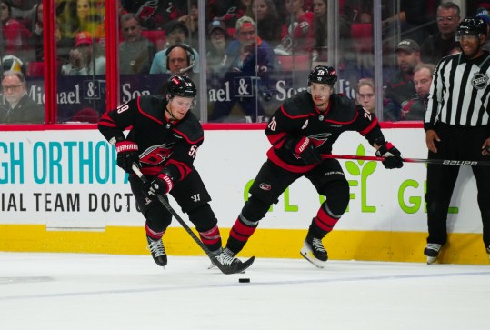 Apr 30, 2024; Raleigh, North Carolina, USA; Carolina Hurricanes center Jake Guentzel (59) and center Sebastian Aho (20) skate up the ice with the puck against the New York Islanders during the third period in game five of the first round of the 2024 Stanley Cup Playoffs at PNC Arena. Mandatory Credit: James Guillory-USA TODAY Sports