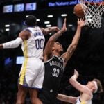 Feb 5, 2024; Brooklyn, New York, USA; Brooklyn Nets center Nic Claxton (33) drives for a shot as Golden State Warriors forward Jonathan Kuminga (00) and guard Brandin Podziemski (2) defend during the first quarter against the Brooklyn Nets at Barclays Center. Mandatory Credit: Vincent Carchietta-USA TODAY Sports