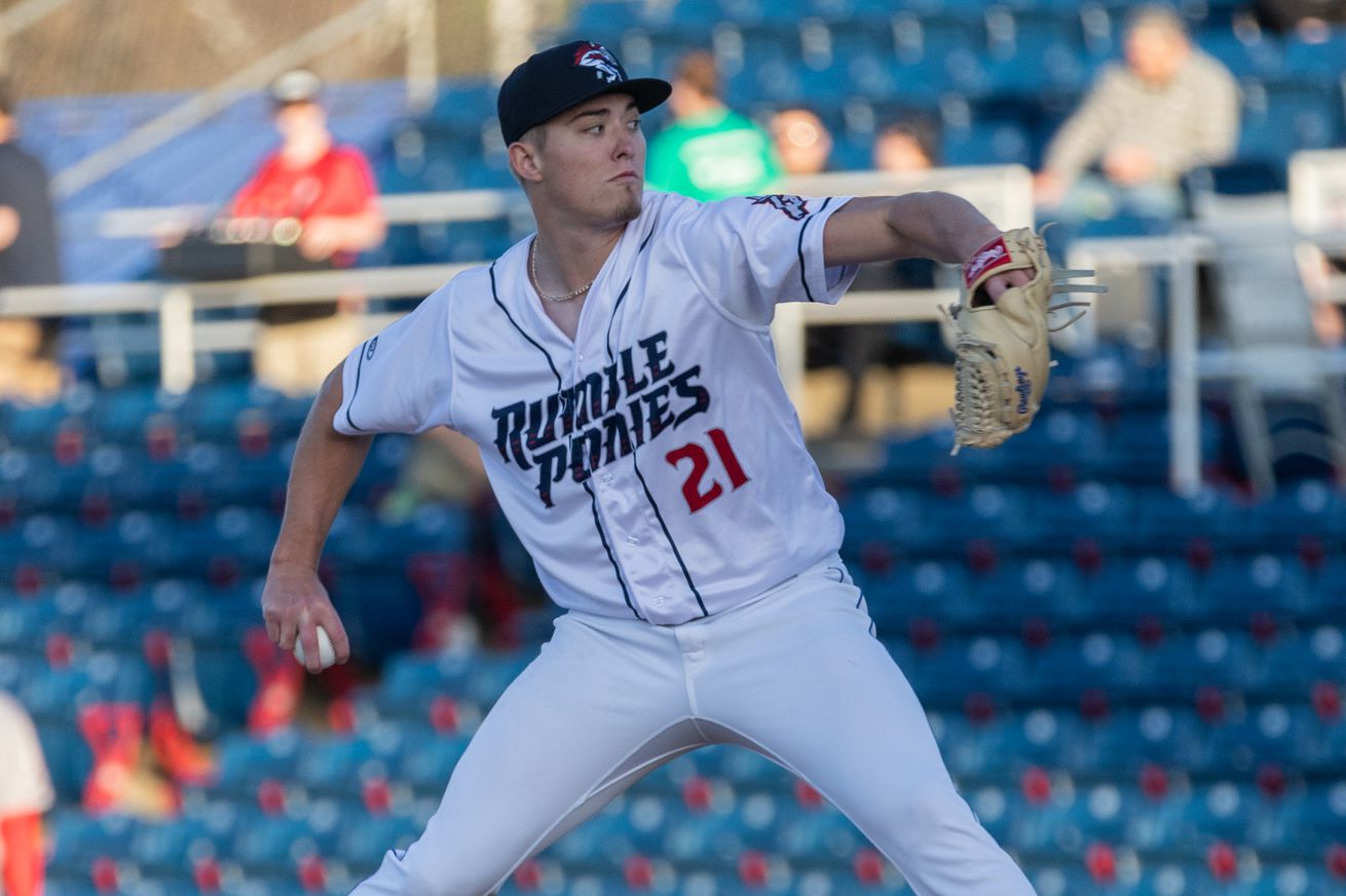 Blade Tidwell throws a pitch in a white Rumble Ponies uniform with a blue hat, blue lettering, and his number 21 in red.