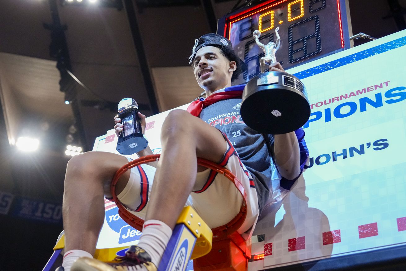 RJ Luis Jr. #12 of the St. John’s Red Storm sits on top the basket with his Most Outstanding Player trophy after the Red Storm won the championship of the Big East Men’s Basketball Tournament over the Creighton Bluejays at Madison Square Garden on March 15, 2025 in New York City.
