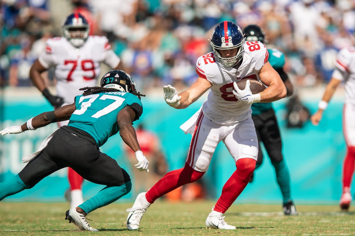 Oct 23, 2022; Jacksonville, Florida, USA; New York Giants tight end Daniel Bellinger (82) catches the ball against Jacksonville Jaguars cornerback Tre Herndon (37) in the second quarter at TIAA Bank Field. Mandatory Credit: Jeremy Reper-USA TODAY Sports