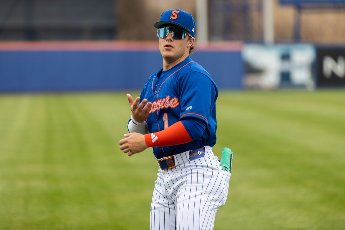 Drew Gilbert warms up in a blue Syracuse Mets jersey and hat with white pants with blue pinstripes.