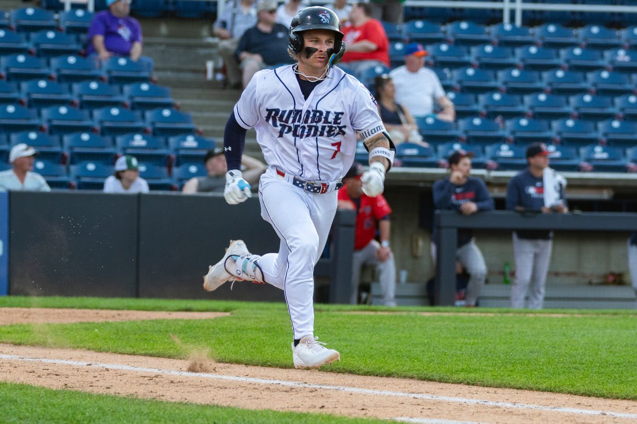 Jett Williams running to first base in a white Rumble Ponies uniform