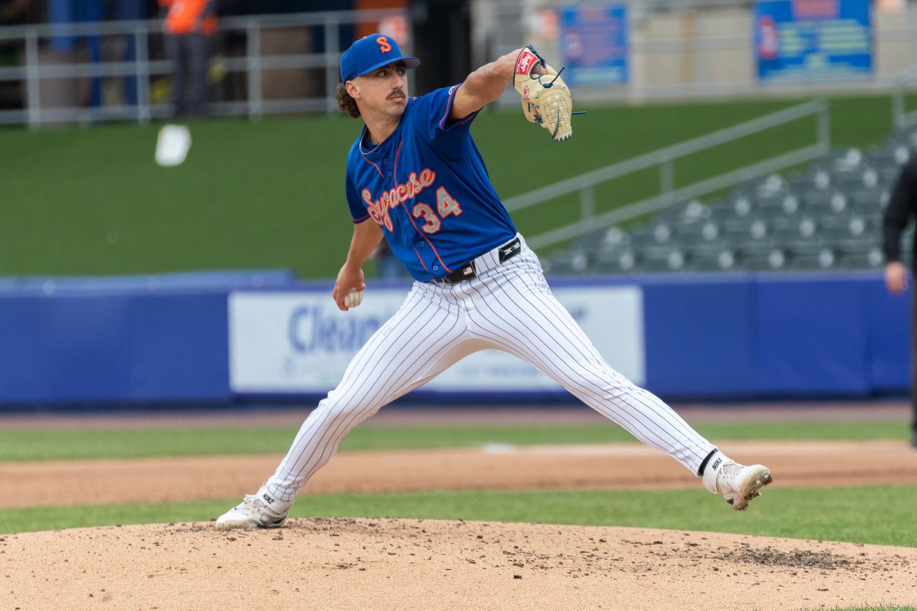 Brandon Sproat throws a pitch in a blue Syracuse Mets uniform with orange and grey script and white pants.